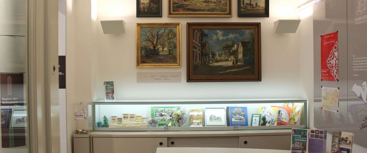 Empfangsbereich mit Tresen und Blick auf Gemälde mit Coswiger Gebäuden