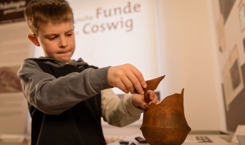 Junge baut Modell-Vase zusammen