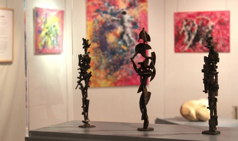 Ausstellungsansicht mit drei Bronzefiguren im Vordergrund